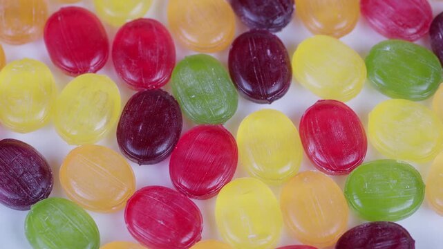 Detailed macro view of multicolored candies on white backdrop. Highresolution image showcasing cheerful assortment of brightly colored candies with shiny exteriors