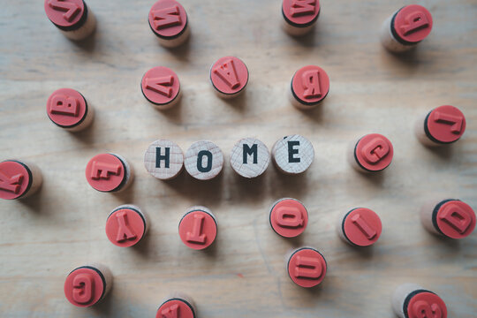 Wooden blocks spelling  HOME on wood table, symbolizing home loans and mortgages.
