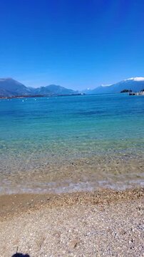 Lido di Manerba at Lago di Garda shows boats on clear water and mountains in the distance