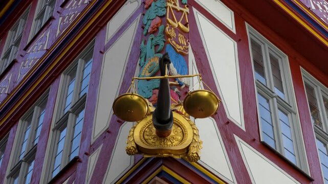 Decorative golden scale sign on historic half timbered facade at Stoltze Museum in Frankfurt old town with detailed architectural elements