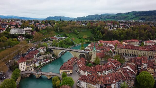 Aerial: Bear Pit, Aare river and Nydeggbrucke with moody sky in Bern, capital city of Switzerland, orbit drone shot