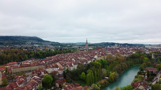 Aerial: Bern old town cityscape with moody sky in capital city of Switzerland, Canton of Bern, establishing drone shot