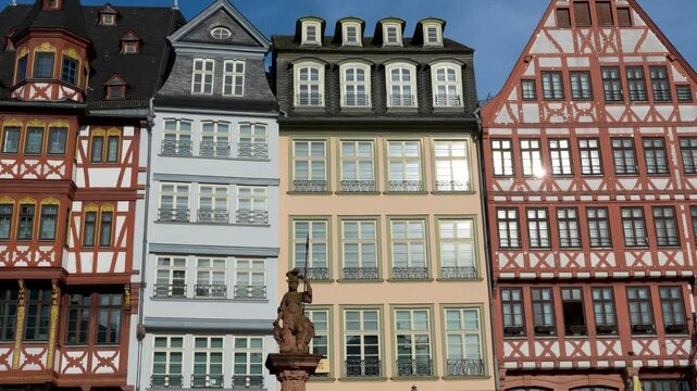 Colorful historic buildings at R&ouml;mer square in Frankfurt with central statue and traditional half timbered architecture in old town