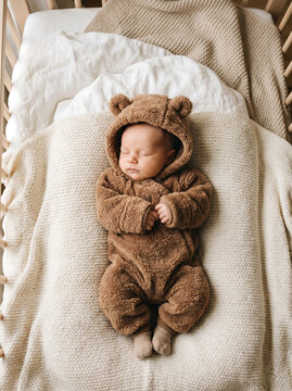 Cute Sleeping Newborn Baby in Brown Bear Onesie