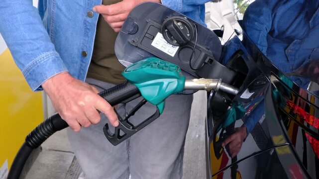 Mid Shot of Unrecognizable Man Hands Removing Fuel Pump Handle from Car Tank at Gas Station After Refueling, Concept of Rising Fuel Prices and Transportation Costs.