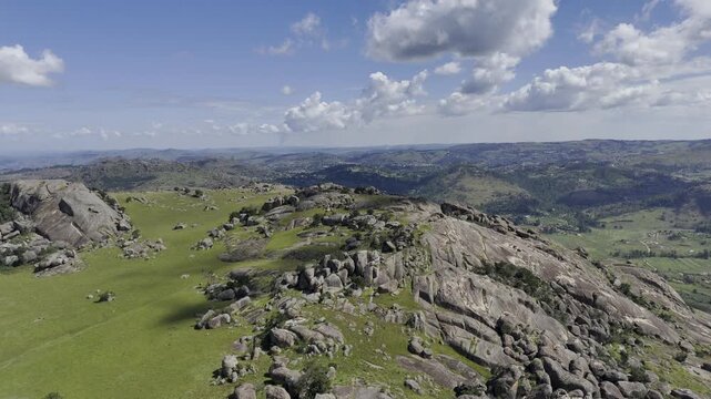 Drone hovers over mountain landscape as clouds pass and cast shadows on a sunny day at Sibebe Rock near Mbabane, Eswatini