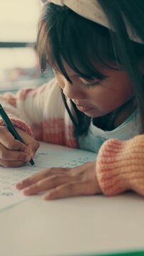 Writing, education and child in classroom at school with learning for test, assignment or quiz. Scholarship, growth and girl student with activity for development, studying or knowledge in lesson.