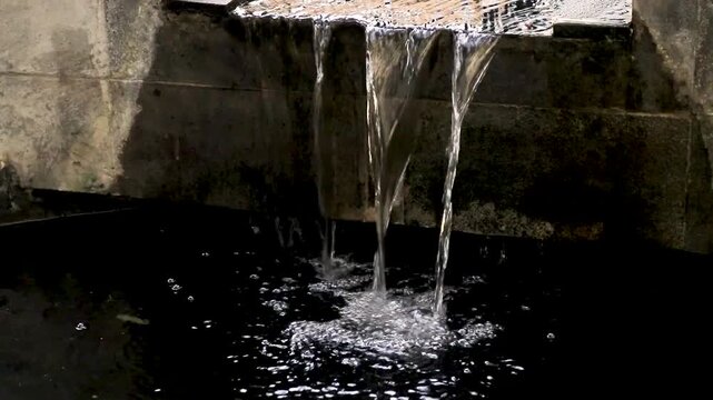 Beautiful water fall in koi pond in the garden, mini waterfall flowing in a fish pond