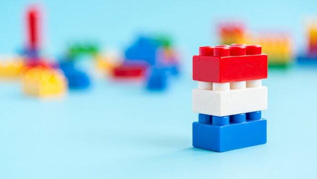 A stack of colorful plastic building blocks on a blue surface with blurred background
