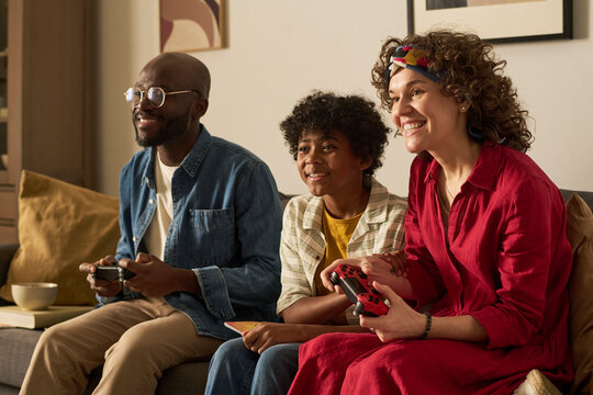 Family playing video game together on couch at home