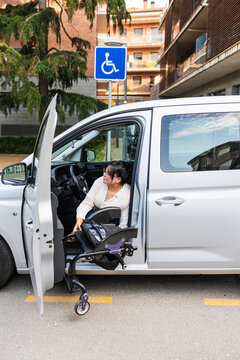 Woman loading wheelchair into vehicle for mobility and accessibility