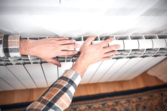 Man heating on a chilly winter day, energy and gas crisis, cold room, heating problems.