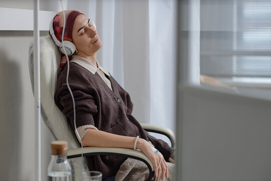 Woman with headscarf receiving IV cancer treatment at clinic