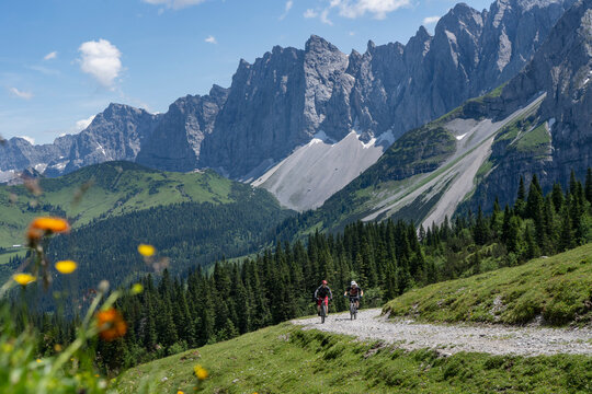 Cyclist riding e-mountain bikes on trail in alpine Bavarian Karwendel mountains