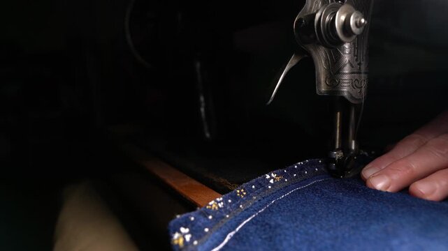 Old sewing machine in use at home, sewing on a vintage machine, seamstress working