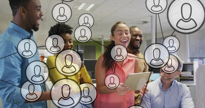 Presenting woman in sleeveless pink top holding tablet, team watching at office with network icons