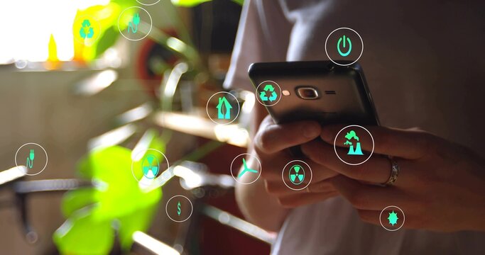Holding smartphone, woman in white shirt tapping screen at home by window, eco icons and ring