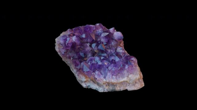 A purple amethyst druse isolated on a black background in loop