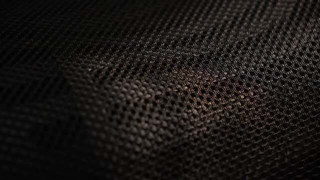 Close-up textured dark fabric surface with mesh pattern