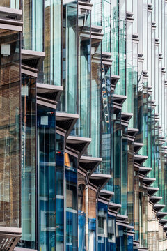 Architecture detail in blue glass facade where modern windows create vertical pattern and structure for abstract urban city composition