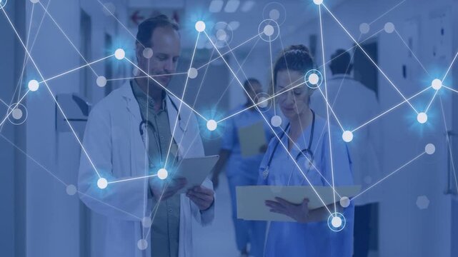 Two clinicians walking corridor checking tablet, folder while network growing from left aiding care
