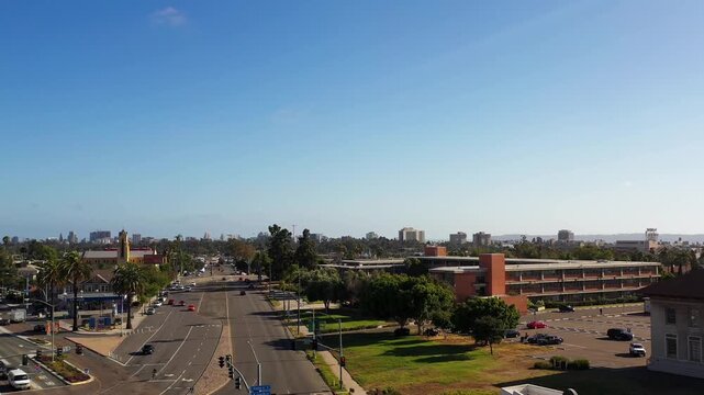 Drone pulling back and rising over North Park at 5PM revealing the downtown San Diego skyline in the distance.