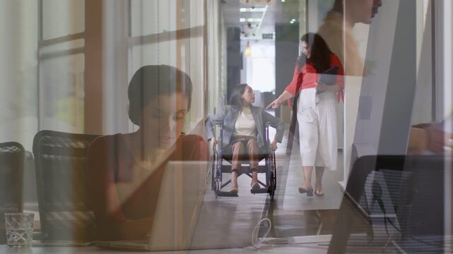 Wheelchair user and peer moving down office hall after tapping phone, AR arrows appearing