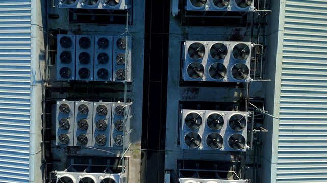 Top down macro aerial perspective of spinning HVAC cooling turbines on a digital infrastructure building