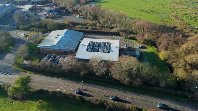 Aerial drone view of a large data center building featuring rotating cooling fans on the rooftop in Redditch, UK