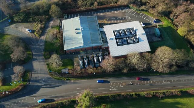 High angle drone shot of active industrial HVAC cooling units on the roof of a modern server farm facility