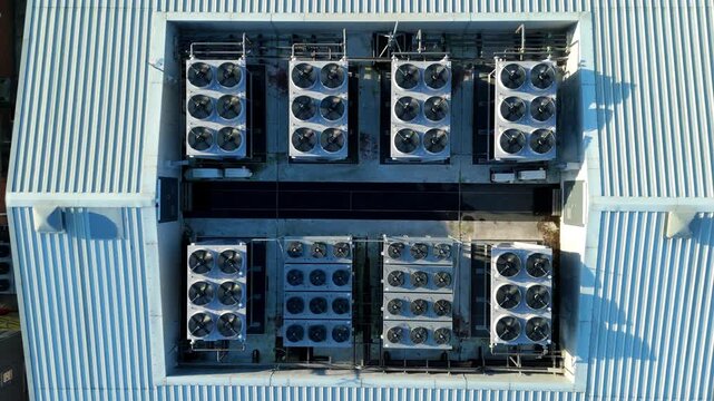 Detailed drone shot of active ventilation systems and spinning rooftop fans on a high-tech server facility