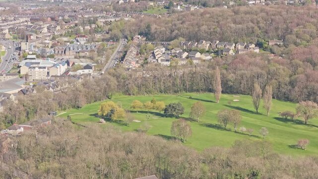 Greenhead Park in Huddersfield Kirklees West Yorkshire England United Kingdom with grassland trees woodland edge and surrounding residential area, drone ascent aerial shot