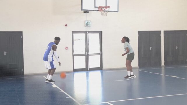 Blue jersey shooting orange ball rebounding light-shirt grabbing dribbling during sports practice