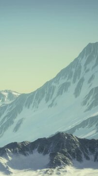 Snowy mountain ranges stretch across the horizon, their steep slopes glistening in the soft morning light. A tranquil atmosphere surrounds this breathtaking natural beauty, inspiring awe.