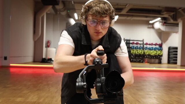 Professional videographer precisely adjusts camera on gimbal in studio focusing on smooth motion perfect framing and technical control demonstrating skill and confidence in video production