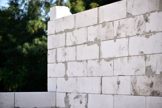 Unfinished walls made of white aerated concrete blocks. Construction site of a utility room under construction. Engineering technology, construction. Foam concrete block. work is underway block laying