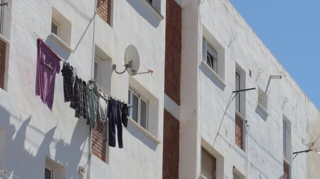 Laundry drying on a balcony in an apartment building on a sunny day in the city