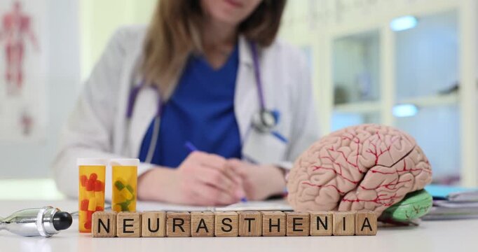 Wooden blocks spell word Neurasthenia near brain model and pill bottles. Doctor reviews report tracking fatigue symptoms while planning support care
