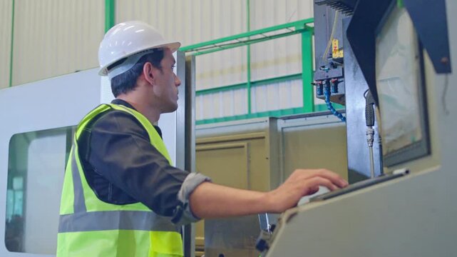 Industrial operator managing equipment manufacturing facility action shot controlled environment close-up view precision work