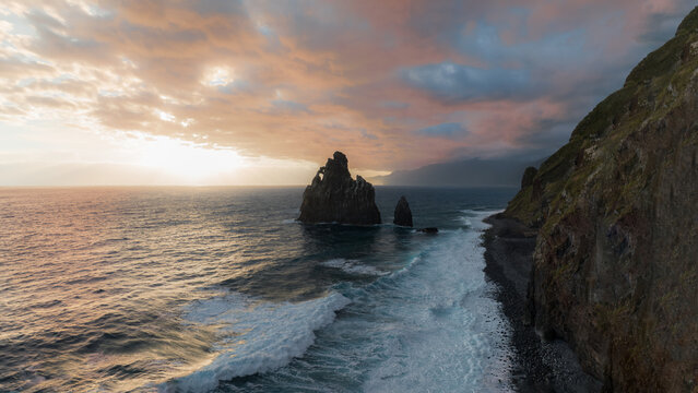 Aerial view of the Ribeira da Janela sea stacks rising from the Atlantic Ocean along the rugged coastline under a sunset sky Ribeira da Janela, Madeira, Portugal.