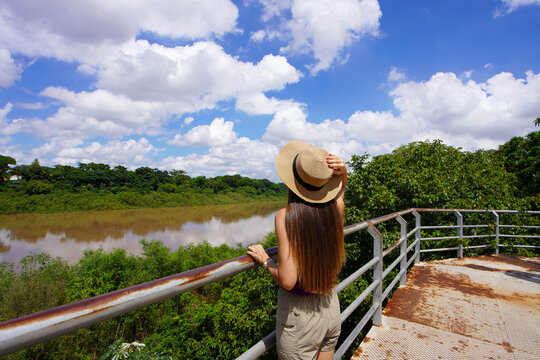 Back view of young traveler woman visiting the Pantanal the world's largest tropical wetland area with the Cuiaba River, Mato Grosso, Brazil