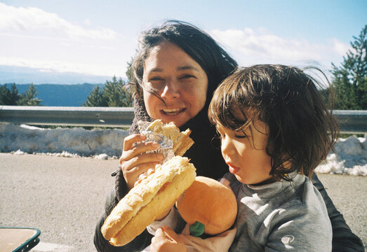analog film photo mother daughter having pic nic outdoors, eating sandwich outdoors on a sunny day, happy memories