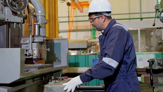 Machinist operating equipment in industrial facility manufacturing process workshop professional viewpoint engineering concepts