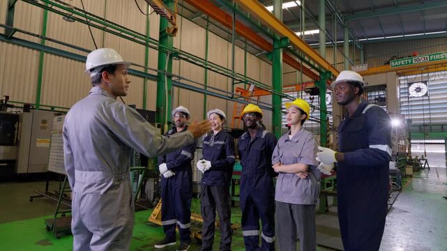 Team meeting amidst factory operations manufacturing plant group discussion industrial environment professional viewpoint safety culture
