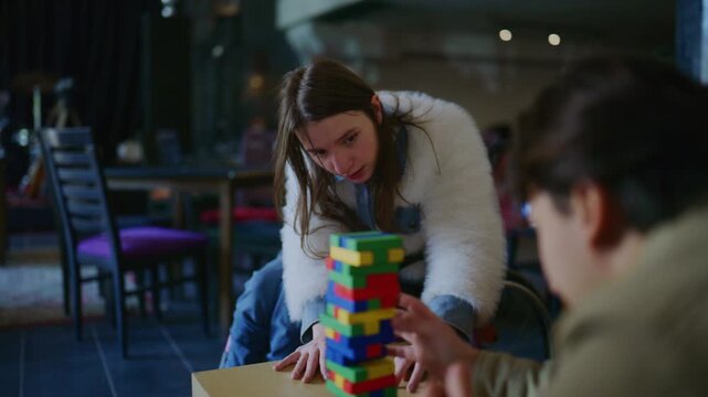 Students intently focus on a challenging stacking block game. Young people engage in a fun and interactive board game.