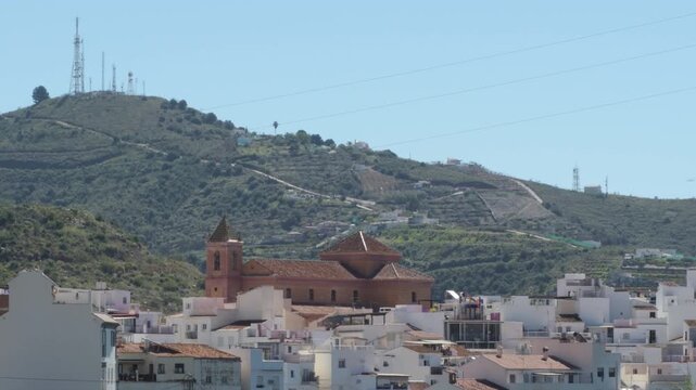 Church stands tall over small town with mountains, Torrox, Spain