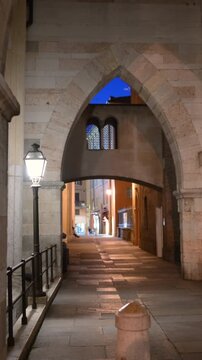 Modena, italy, april 11, 2026. Old medieval arched street illuminated by warm streetlights at night. Narrow cobblestone passage in the historic center of modena