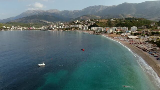 Beautiful aerial panorama of Himare beach along the Albanian Riviera. Turquoise and blue waters of the Ionian Sea meeting the coast