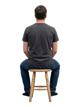 Man sitting on stool from behind on white background
