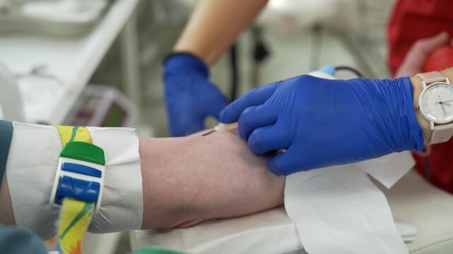 Close-up of a Medical Professional Inserting a Needle into a Patient's Arm for Blood Donation or IV Therapy, Professional Healthcare Procedure in a Clinical Setting.